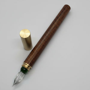Wooden glass nib with green strip, calligraphy pen with brass ferrule on a white background